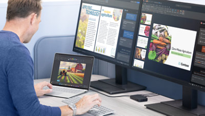A person works from a desk using Surface USB4 Dock to connect their Surface Laptop to two external monitors.
