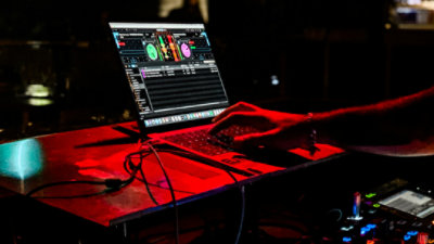 An image of a DJ using a laptop to mix music