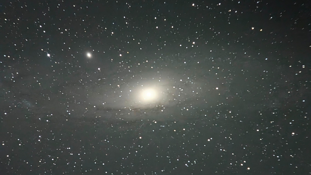 A picture of the Andromeda spiral galaxy pictured against a star-studded sky.