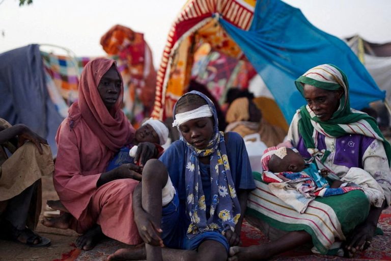 The grandmother of Ikram Abdelhameed looks on next her family while sitting at a camp for displaced people who fled from a...