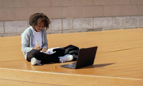 Person making notes with laptop