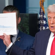 Trump holds up a printed out graph during a press conference.