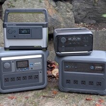 portable power stations from anker, goal zero, and ecoflow arranged together in front of a rockery with fall leaves on the ground