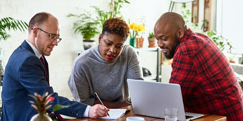 Couple listening to financial advisor about whether they need life insurance at home with laptop.