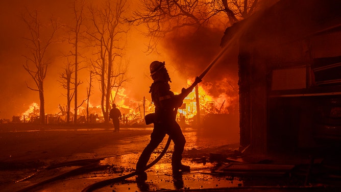 Firefighters battle the Eaton Fire in strong winds as many homes burn on January 7, 2025 in Pasadena, California.
