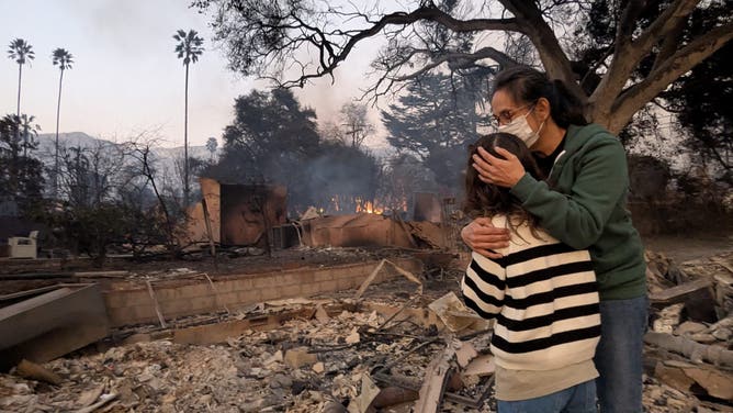 Marcy Harbut and her 12-year-old daughter at what's left of their home after the Eaton Fire in January 2025.
