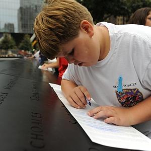 August Larsen, 9, makes a crayon rubbing of his father's name, Scott Larsen, who he never got a chance to meet. Larsen, a firefighter at Ladder 15, was killed in 9/11 just days before his son was born.