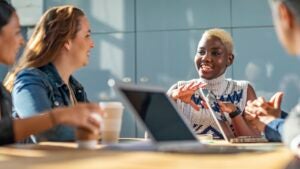 A business meeting led by a young Black woman with bleached hair.