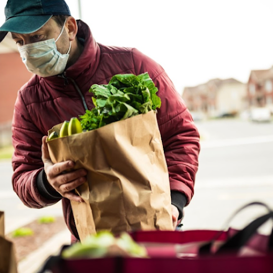 Person carrying a bag of groceries with an overlay that reads, “50% cut down on reporting time.”