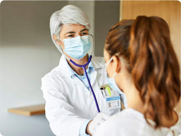 A doctor listening to a patient's breathing with a stethoscope.