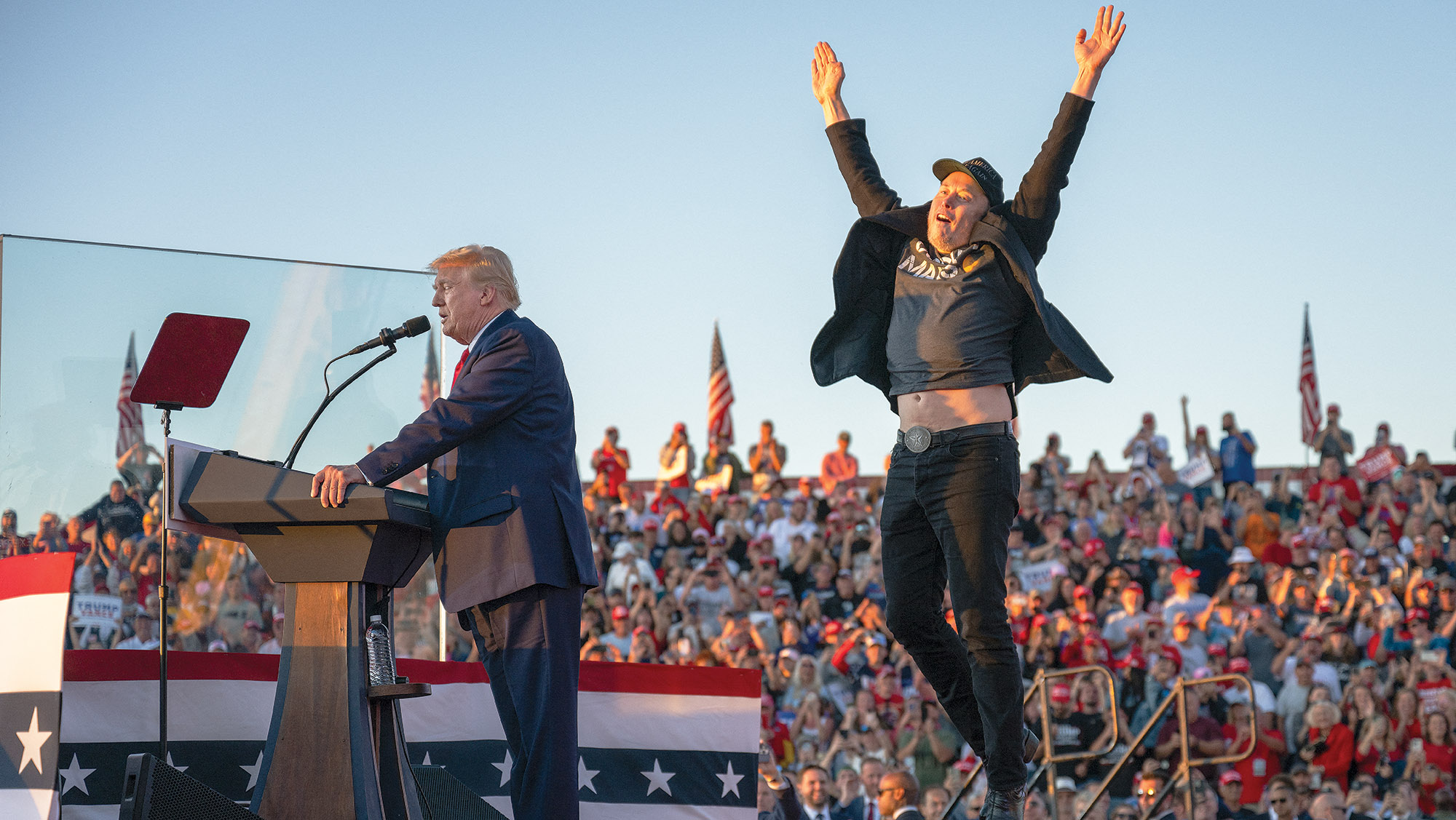 Tesla CEO Elon Musk (R) jumps on stage as he joins former US President and Republican presidential candidate Donald Trump during a campaign rally at site of his first assassination attempt in Butler, Pennsylvania on October 5, 2024.