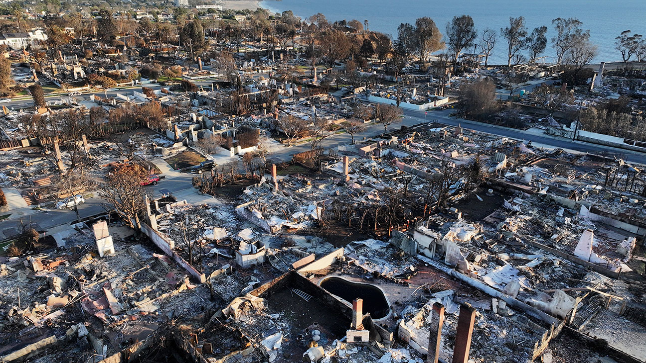 An aerial view shows homes destroyed in the Palisades Fire with the Pacific Ocean in the distance on January 27, 2025 in Pacific Palisades, California.