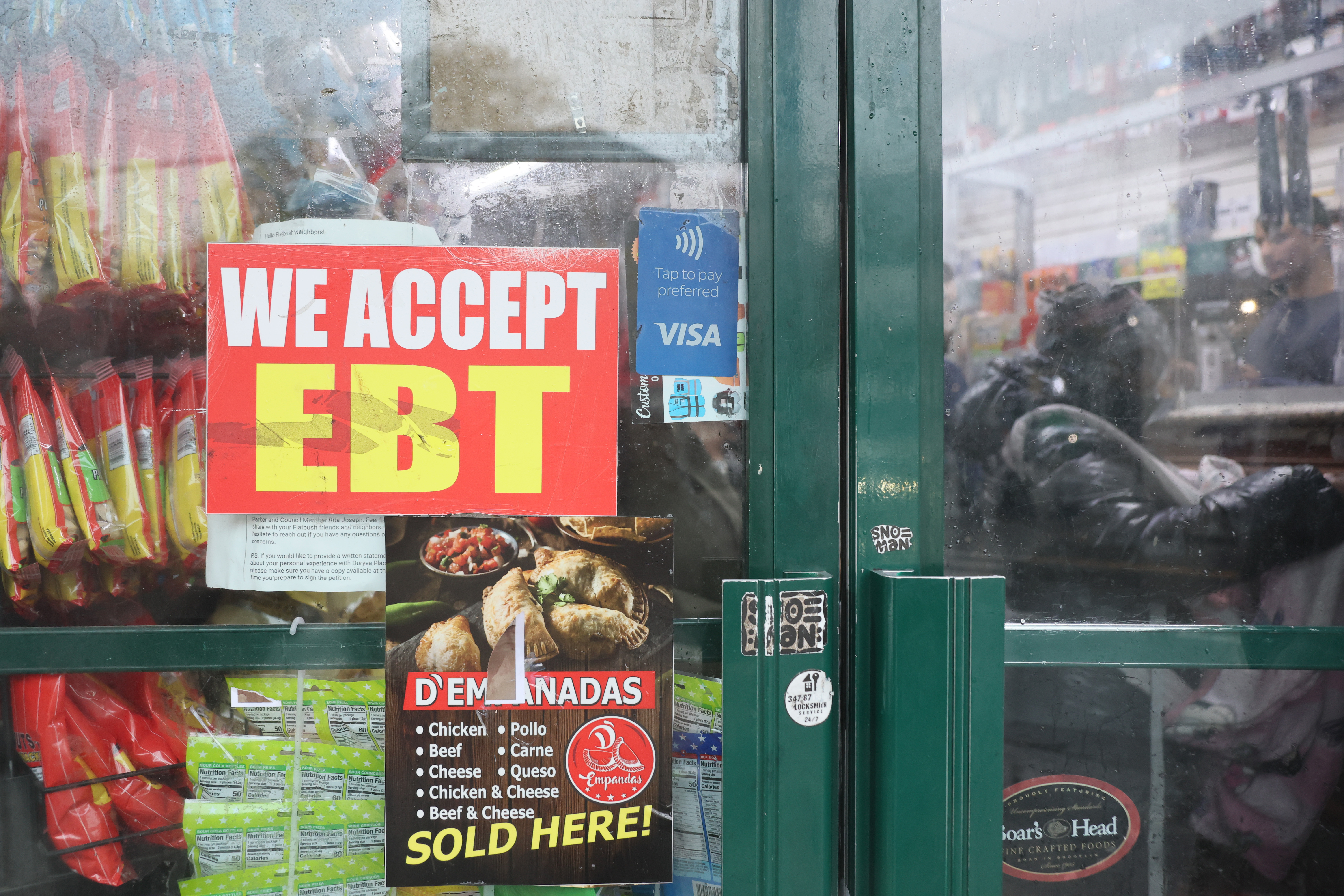 An EBT sign is displayed on the window of a grocery store in Flatbush.